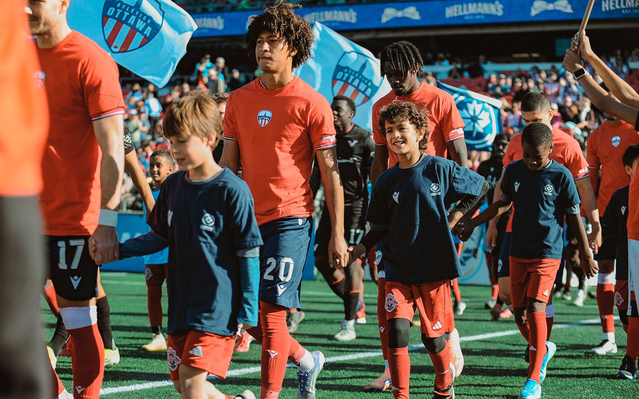 Soccer players walking with young fans