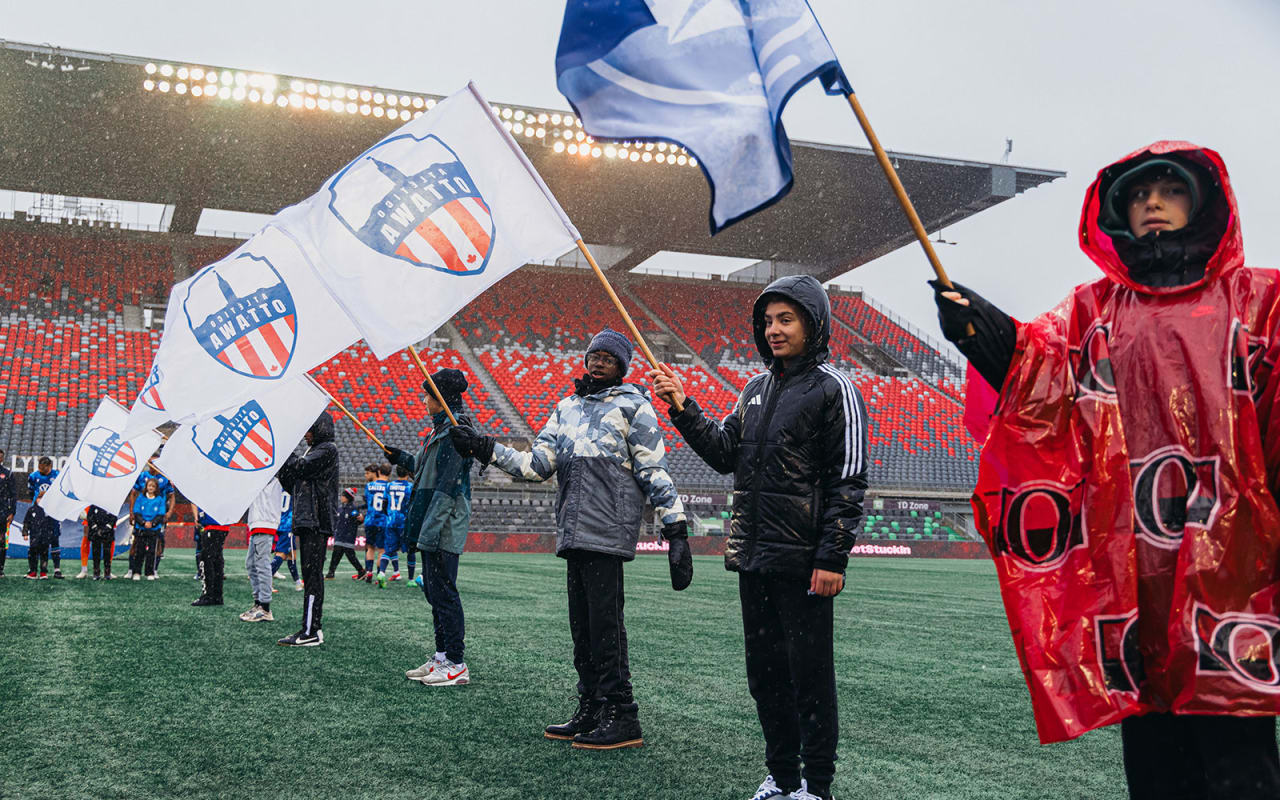 kids holding flags on a soccer field
